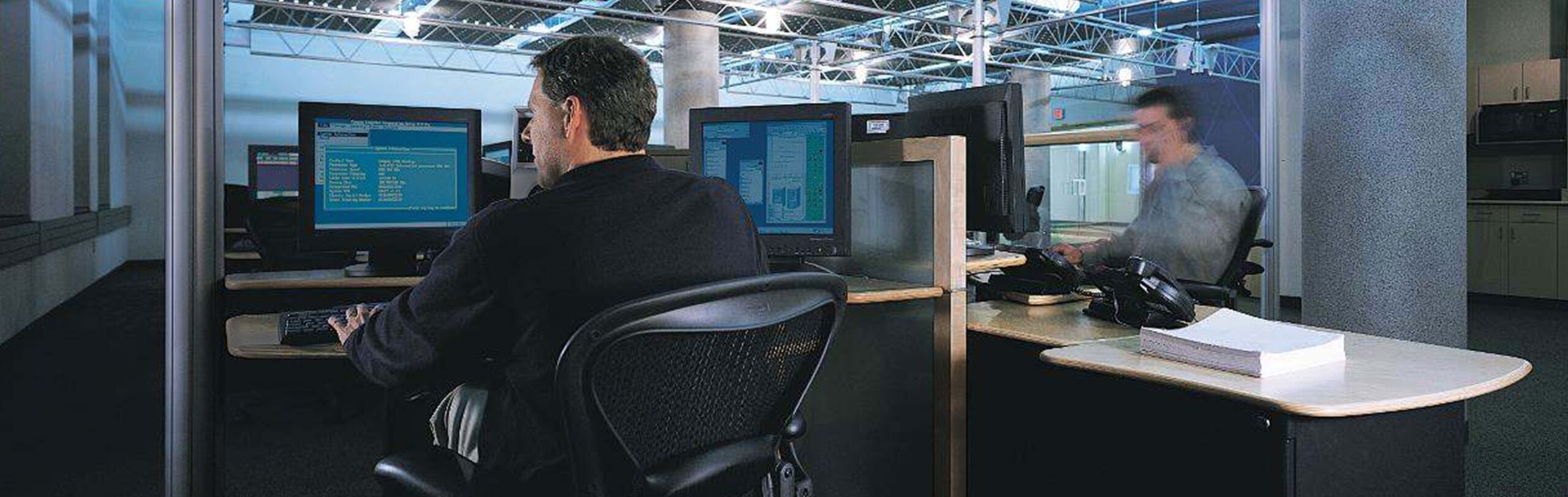 Interiors of an office with people working at desktops